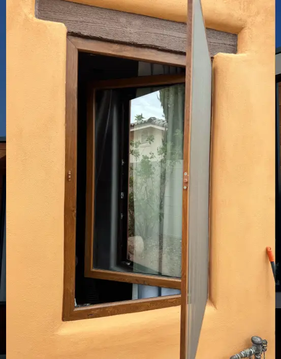 A window with a wooden frame and a curtain
