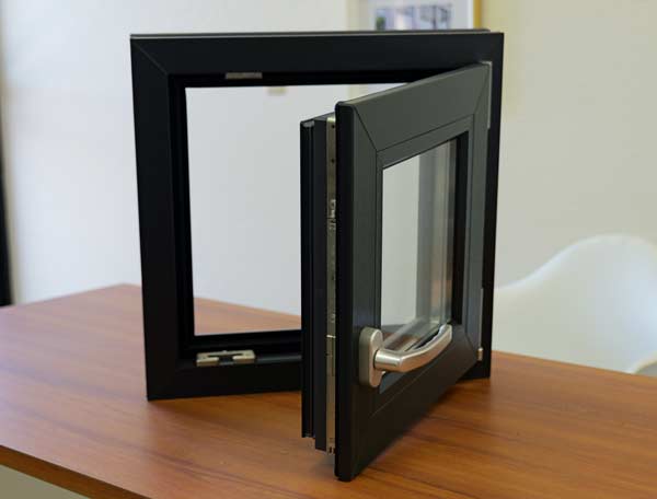 Modern black window frame with dual-function opening mechanism, showcasing European design and American craftsmanship, placed on a wooden surface.