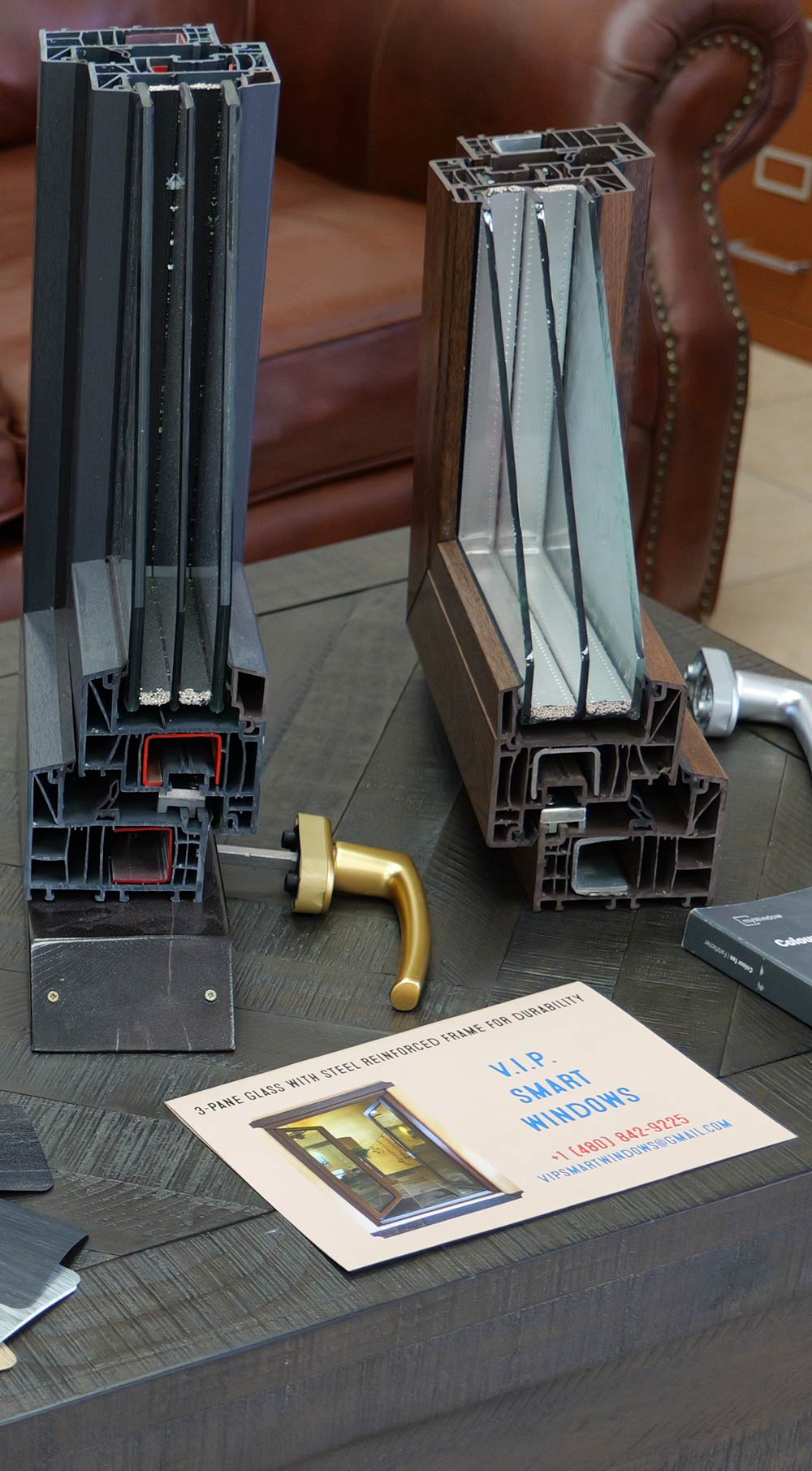 Cutaway view of VIP Smart Windows showcasing energy-efficient window frames with tilt-and-turn operation, steel-reinforced design, and a brochure detailing features and contact information on a wooden table.