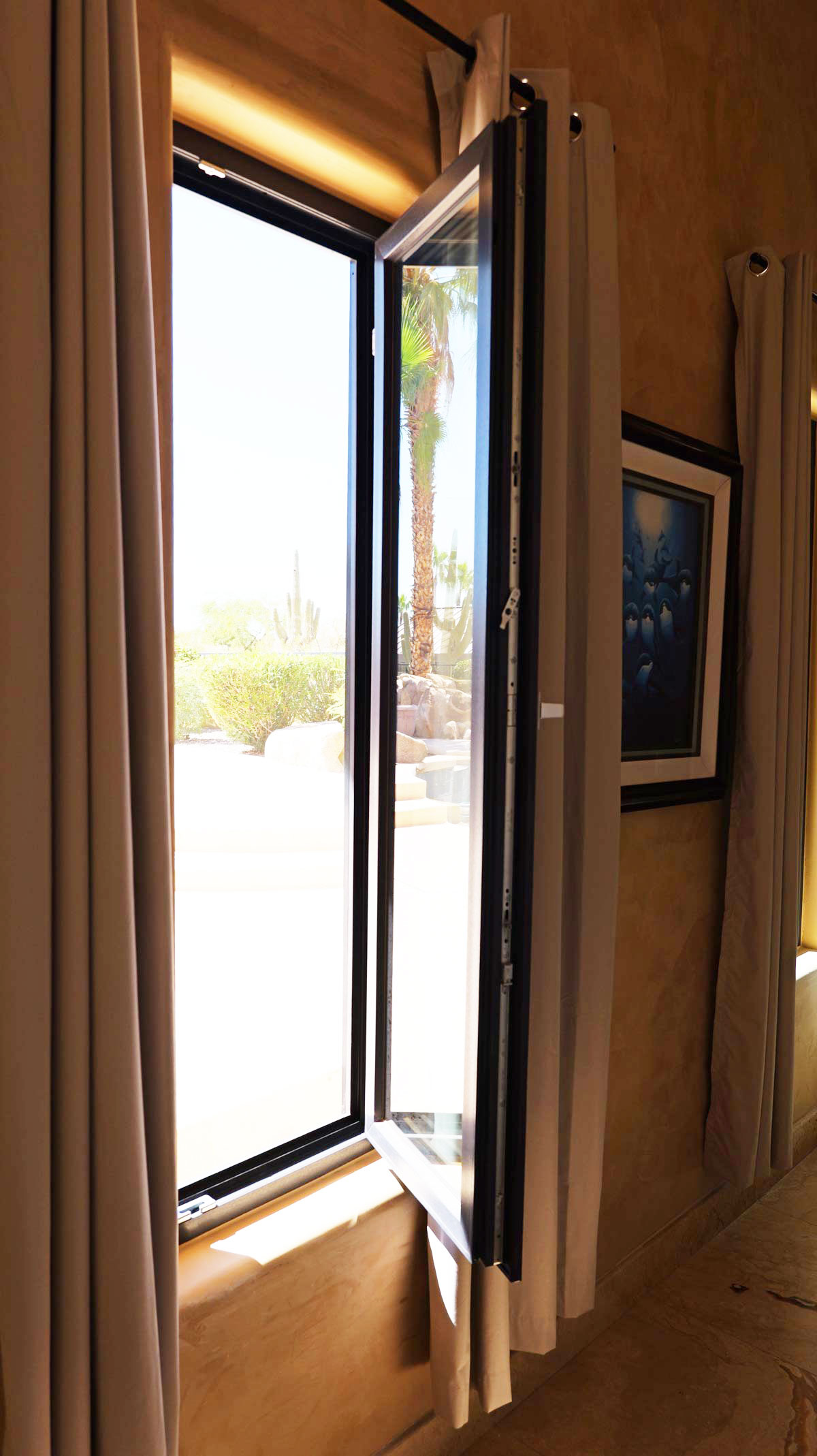 Tilt-and-turn window showcasing Italian hardware, open to reveal outdoor scenery, emphasizing energy efficiency and modern design.